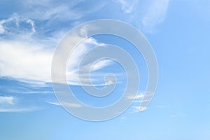 White fluffy cirrus clouds in a stratosphere. Light translucent fiber like spindrift clouds high in the blue summer sky. Different