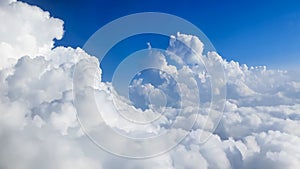 White fluffy clouds in an amazing cloudscape from above against a blue sky