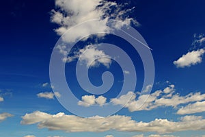 White, fluffy clouds in blue sky. Background from clouds.with airplane vapour trail