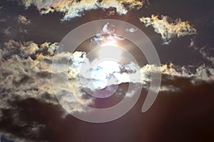 White fluffy clouds in the blue sky. Dramatic cloudscape with sun rays