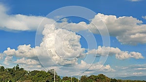 White fluffy clouds on blue sky over trees and electric wires in Nueva Ecija, Philippines