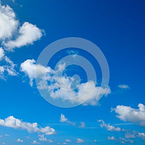 White fluffy clouds and bright sun on blue sky