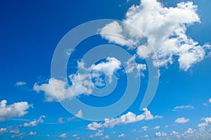White fluffy clouds and bright sun on blue sky