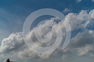 White fluffy clouds rise from left to right across the blue sky, abstractly hinting at the right direction for growth photo