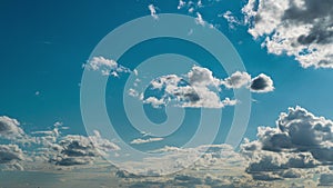 White Fluffy Clouds Slowly Float Through the Blue Daytime Sky Timelapse