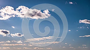 White Fluffy Clouds Slowly Float Through the Blue Daytime Sky Timelapse