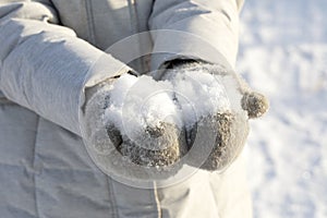 White fluffy snow in hands of those wearing mittens