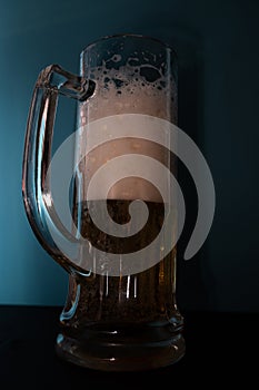 White foam in a beer glass. Shaded background.