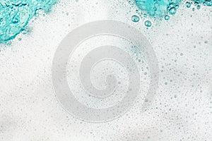 White foam blue water background closeup, sea or ocean foam wave pattern, froth bubbles texture, soap spume backdrop, soap sud