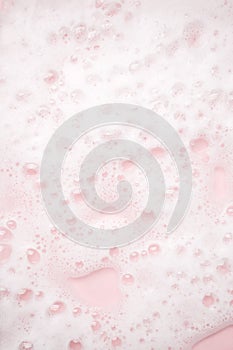 White foam bubbles texture on pink pastel background, copy space, banner for loundry, cleaning service, bathroom concept, clean,