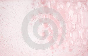 White foam bubbles texture on pink pastel background, copy space, banner for loundry, cleaning service, bathroom concept, clean,