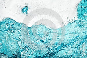 White foam clear blue water background closeup, sea or ocean foam wave border, froth bubbles texture, lather backdrop, soap suds