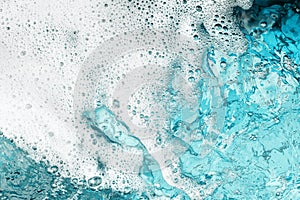 White foam clear blue water background closeup, sea or ocean foam wave border, froth bubbles texture, lather backdrop, soap suds