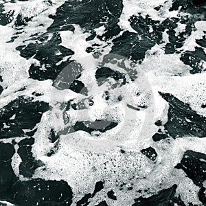 White foam on the surface of crystal clear sea water