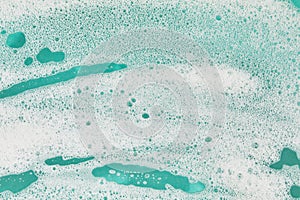 White foamy suds on teal background with copy space