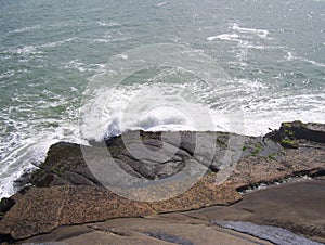 White foamy waves of sea splashing on rocks in beach