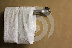 White folded bathroom towel on a rack