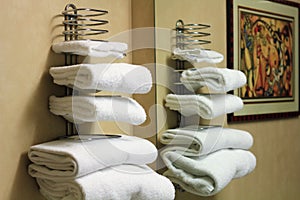 White folded bathroom towels on a rack