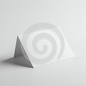 A white folded card stands on a smooth, white surface. The card is positioned at an