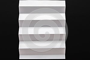 White folded sheet of paper on black background