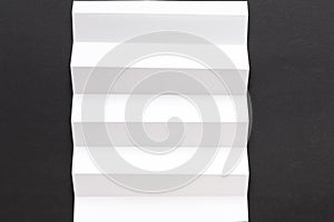 White folded sheet of paper on black background