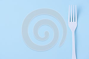 White fork on trendy soft blue paper backgroun