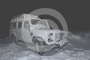 White foru-wheel vehicle in the mountain during the snowy foggy night