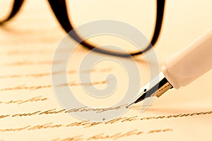 White fountain pen writing a letter, glasses
