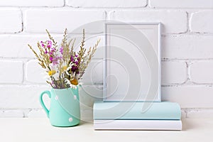 White frame mockup with chamomile and purple flowers in mint green pitcher and books