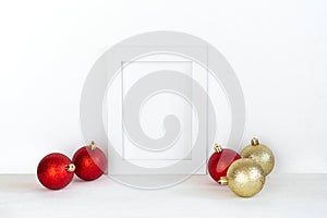 White frame mockup with Christmas decorative elements on the shelf. Portrait frame on a white wall