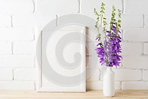 White frame mockup with purple campanula bouquet near brick wall