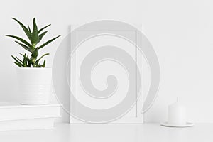 White frame mockup with workspace accessories and a aloe vera on a white table.Portrait orientation