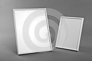 White frames for paintings or photographs on gray background.