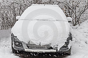 White fresh snow is on a silver dirty wet car outdoor in winter