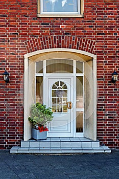 White front door with windows in a private residential brick house in Germany