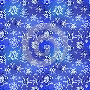 White frozen snowflakes on blue winter background, seamless pattern