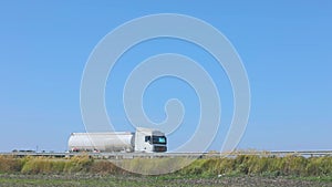 White fuel truck driving along the highway. A fuel truck drives on the highway in good weather