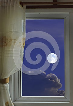White full moon and clouds in the window view at night