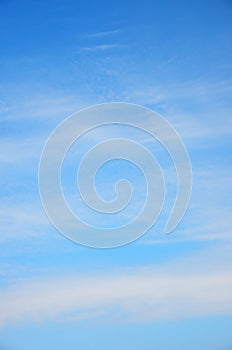 White fuzzy stripes clouds in blue sky