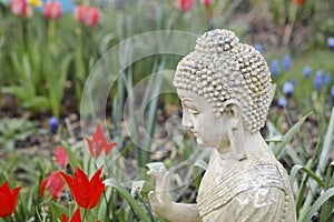 White garden buddha with tulips