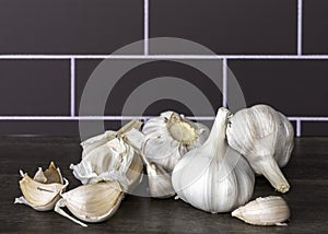 White garlic bulbs (Allium sativum) on wooden table.