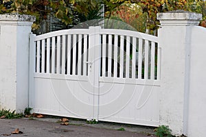 White gate aluminum portal with blades in city suburbs house street