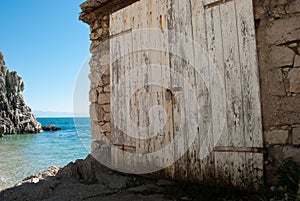 A white gate of a boathouse in front of the sea