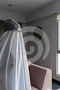 White ghost with black eyes, made from a bedsheet. whit hat