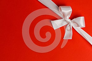 White gift bow on red