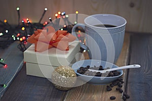 White gift box, blue cup, coffee beans in a bowl, golden ballnn
