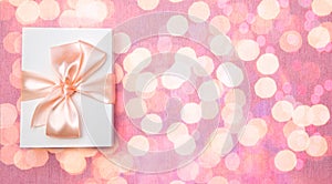 White gift box with bow on bokeh background. Baner