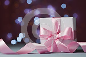 White gift box or present against magic bokeh background. Greeting card for Christmas, New Year or wedding.