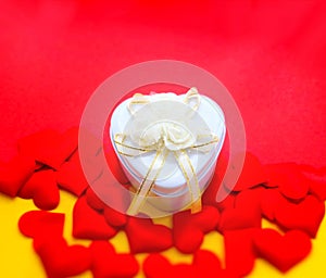 White gift box and red hearts on red  yellow background. Symbol of love, romantic.  Happy Woman`s Day, Mother`s Day, Valentine`