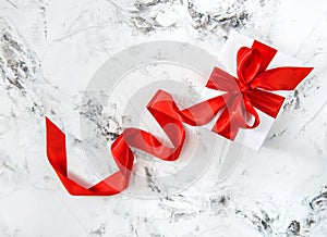 White gift box red ribbon bow bright marble background